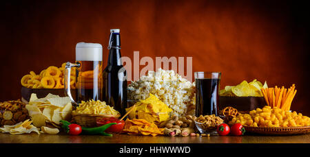 Panoramablick von Salty Snacks und Getränke auf Holztisch im Still-Leben Stockfoto