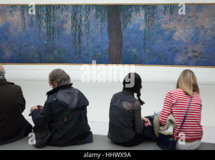 Besucher vor den Bildern aus dem Zyklus angezeigt Nympheas (Seerosen, 1920-1926) französischen impressionistischen Malers Claude Monet im Musee de l ' Orangerie in Paris, Frankreich. Stockfoto