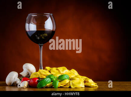 Glas Rotwein mit Ravioli Pasta und Pilze und Kopie Stockfoto