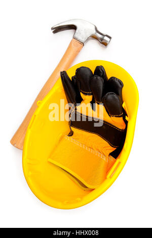 Zwei Lederhandschuhe des Erbauers in einen Helm mit einem Zimmermannshammer Stockfoto