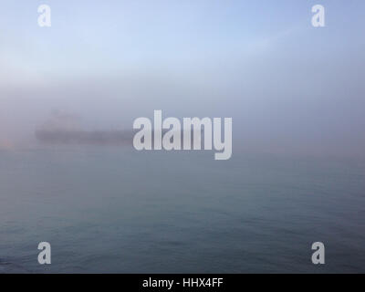 Boot bewegt sich in dichtem Nebel früh Wintermorgen Stockfoto