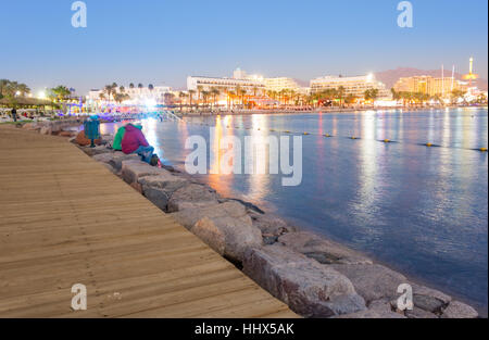 Sonnenuntergang und blaue Stunde an der Uferpromenade von Eilat am Roten Meer Golf von Aqaba mit Eilats Hotels im Hintergrund. Eilat ist Israels größte Urlaub reso Stockfoto