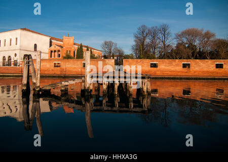 Ein Gebäude von San Servolo reflektiert Insel im Wasser der Lagune von Venedig. Stockfoto