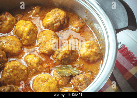 Pfanne mit Fleischbällchen in Tomaten-Curry-Sauce. Stockfoto