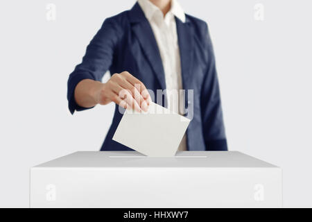 Frau einen Stimmzettel in eine Abstimmung Box setzen. Stockfoto