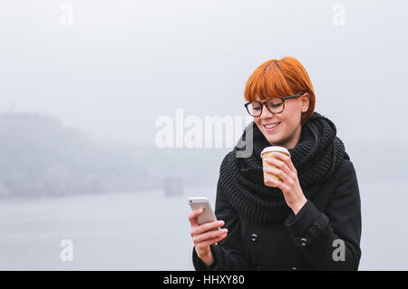 Junge, moderne Geschäftsfrau. Porträt des jungen Mädchens, das Smartphone überprüft. Stockfoto