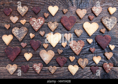 Leckere Cookies in Herzform gebacken mit Liebe auf hölzernen Hintergrund Stockfoto