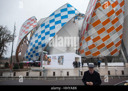 Schlange von Besuchern die Fondation Louis Vuitton im Bois De Boulogne in Paris, Frankreich. Leute warten auf die Sicherheitskontrolle zum Besuch der Ausstellung Ikonen der modernen Kunst aus der Sammlung Schtschukin. Die Ausstellung läuft bis zum 5. März 2017. Vom Architekten Frank Gehry entworfene Gebäude wurde im Jahr 2014 abgeschlossen. Farbige Segel sind die temporäre Installation mit dem Titel Observatory of Light (2016) vom französischen Künstler Daniel Buren. Stockfoto