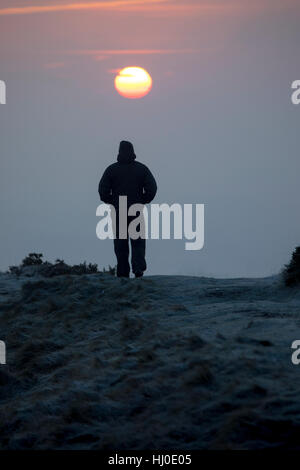 Eine Hügel Walker trotzt der Kälte auf der alten Festung der Moel y Gaer in der Nähe des Dorfes Rhosesmor, Flintshire, Wales Stockfoto