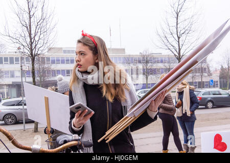 Frau auf dem Fahrrad verteilt Plakate vor der US-Botschaft in Kopenhagen. Sie nimmt Teil an Frauen März, ein weltweiter Protest gegen Donald Trump am 21. Januar 2017, Stockfoto