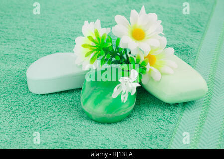 Bunte Seifen und Blumen auf grünem Tuch. Stockfoto