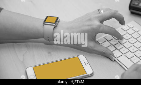 Support-Mitarbeiter über Tastatur eingeben. Aufnahme zeigt auch iWatch und iPhone. Stockfoto