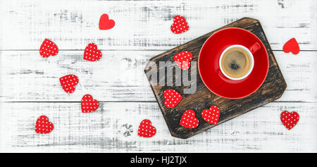 Tasse Kaffee mit roten Herzen Dekoration auf rustikalen hölzernen Hintergrund. Valentinstag-Konzept Stockfoto