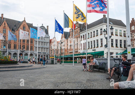 Bunte Fahnen von Fahnenmasten am Marktplatz (Markt) im Zentrum von Brügge, Belgien. Stockfoto