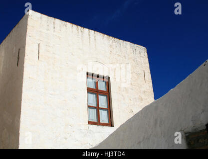 Traditionelle griechische Inselarchitektur mit Holzfenster und weiß getünchter Wand auf Patmos Griechenland Stockfoto