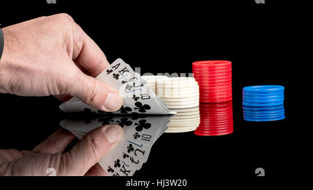 Spielkarten mit Chips auf einer reflektierenden Oberfläche Stockfoto