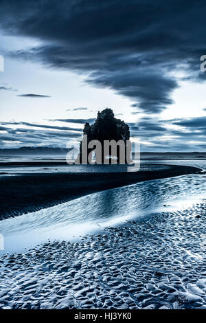 Ein Wahrzeichen Strand in Island namens Dinosaur Rock ragt 50 Fuß aus dem seichten Wasser während eines morgendlichen Sonnenaufgang. Stockfoto