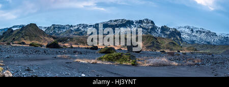 Eine Island-Gebirge-Panorama zeigt die schneebedeckten Berggipfeln mit trockenen Vulkanlandschaft und arktischen Vegetation rund um das Gelände. Stockfoto