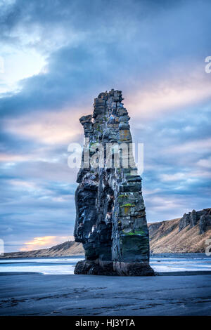 Ein Wahrzeichen Strand in Island namens Dinosaur Rock ragt 50 Fuß aus dem seichten Wasser während eines morgendlichen Sonnenaufgang. Stockfoto