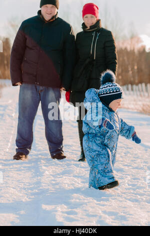 Mama und Papa stehen, betrachtet man sein Kind ein Spaziergang in der Nähe Stockfoto