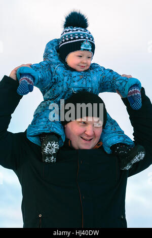 Vater mit seinem Kind auf Schultern Stockfoto