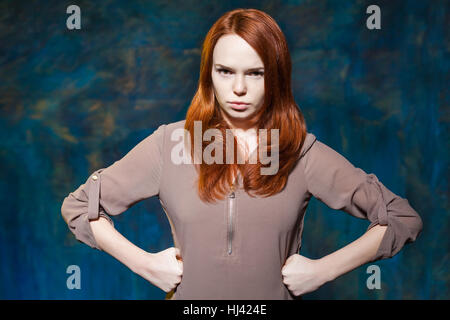 junge rote Haare Frau legte Hände auf die Hüften und streng in die Kamera schaut Stockfoto