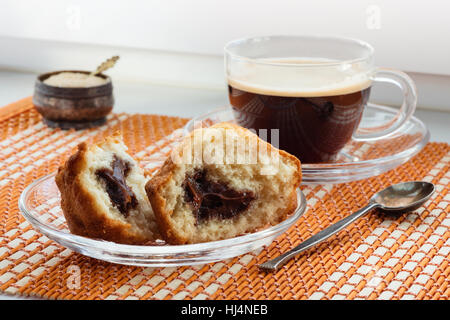 Tasse Kaffee, zwei Hälften Kuchen mit Füllung und einem Löffel Stockfoto