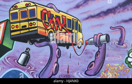 Rivergreenway Graffiti mit der Darstellung eines School Bus hielt aloft durch einen lila Graffiti malen Octopus in Fort Wayne, Indiana, USA. Stockfoto