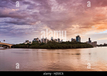 Stadt Brisbane CBD Blick Parklandschaft und Waterfront zwischen berühmten Queenslands Hauptstadt Brücken bei Sonnenaufgang über Brisbane River. Stockfoto