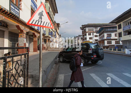 Fußgänger in traditionellen Gho Überquerung auf Hauptstraße (Norzin Lam) in Thimphu, Bhutan. Stockfoto