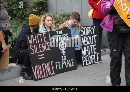 Distrikt von Columbia, USA. 21 Jan, 2017. Drei Demonstranten sitzen auf einer Kandare, mit Zeichen vor Ihnen sagen 'weiße Stille = Gewalt", "DIE ZUKUNFT IST WEIBLICH" mit der feministischen Frau power Symbol und 'Sorry ÜBER WEISSE.". Stockfoto