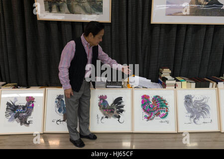 (170126)--Peking, 26. Januar 2017 (Xinhua)--chinesische Künstler Han Meilin, 80, zeigt seine Gemälde der Hähne und Hennen in seinem Atelier im östlichen Bezirk Tongzhou in Peking, Hauptstadt von China, 24. Januar 2017. Han, Designer von den 2008 Olympischen Spiele in Peking Maskottchen "Fuwa," hat gerade die Gestaltung der chinesischen Tierkreiszeichen Briefmarken für das kommende Jahr des Hahnes. Der Satz des chinesischen Lunar New Year Hahn Briefmarken Anfang dieses Monats, enthalten zwei Elemente zeigen stolz schreitende Hahn und eine Henne, die auf der Suche nach ihren beiden Küken. Han angewendet, satten Farben und Elemente der traditionellen chinesischen painti Stockfoto