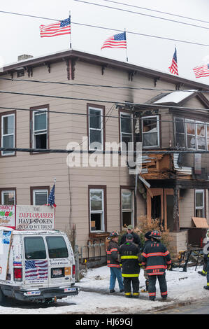 Fitchburg, Massachusetts, USA. 26. Januar 2017. Lokalen und staatlichen Feuer Ermittler außerhalb der so genannten "Trump House" am 19-21 West St in Fitchburg Massachusetts nach dem zweiten Brand in einem Monat beschädigt den hinteren Teil des Gebäudes. Der Schaden oben auf diesem Foto war von einem Feuer am 22. Dezember, die zufällig durch rauchende Materialien in eine äußere Couch erachtet wurde. Das Gebäude war zum Zeitpunkt des Feuers heute Morgen um 06:00 berichtet wurde unbesetzt. Bildnachweis: Jim Marabello / Alamy Live News Stockfoto