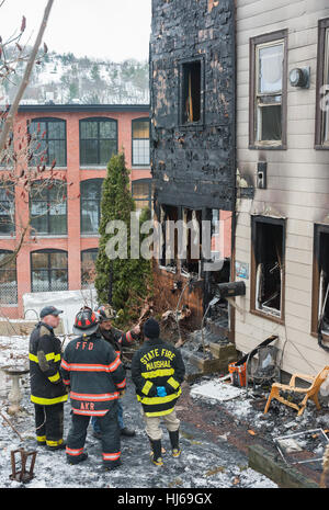 Fitchburg, Massachusetts, USA. 26. Januar 2017. Lokalen und staatlichen Feuer Ermittler Blick auf Schäden an der sogenannten "Trump House" am 19-21 West St in Fitchburg Massachusetts nach dem zweiten Brand in einem Monat beschädigt den hinteren Teil des Gebäudes. Ein Feuer am 22. Dezember wurde als zufällig durch rauchende Materialien in eine äußere Couch. Das Gebäude war zum Zeitpunkt des Feuers heute Morgen um 06:00 berichtet wurde unbesetzt. Bildnachweis: Jim Marabello / Alamy Live News Stockfoto