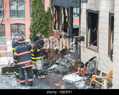 Fitchburg, Massachusetts, USA. 26. Januar 2017. Lokalen und staatlichen Feuer Ermittler Blick auf Schäden an der sogenannten "Trump House" am 19-21 West St in Fitchburg Massachusetts nach dem zweiten Brand in einem Monat beschädigt den hinteren Teil des Gebäudes. Ein Feuer am 22. Dezember wurde als zufällig durch rauchende Materialien in eine äußere Couch. Das Gebäude war zum Zeitpunkt des Feuers heute Morgen um 06:00 berichtet wurde unbesetzt. Bildnachweis: Jim Marabello / Alamy Live News Stockfoto