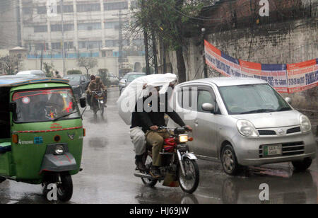 Pendler auf der Durchreise Straße während der schweren Platzregen der Wintersaison in Lahore auf Donnerstag, 26. Januar 2017. Stockfoto