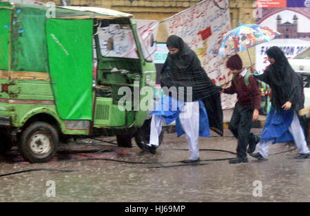 Pendler auf der Durchreise Straße während der schweren Platzregen der Wintersaison in Lahore auf Donnerstag, 26. Januar 2017. Stockfoto