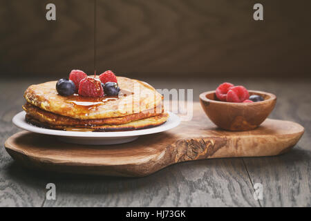 frische hausgemachte Pfannkuchen mit Beeren und Ahornsirup Stockfoto