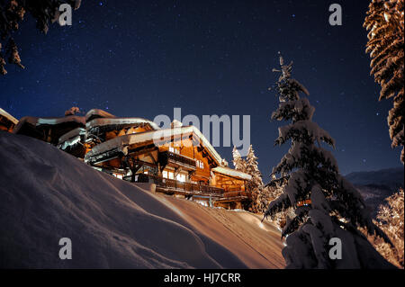 Einen großen schneebedeckten Chalet unter Sternenhimmel in der französischen Skiort Courchevel. Stockfoto