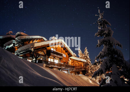 Einen großen schneebedeckten Chalet unter Sternenhimmel in der französischen Skiort Courchevel. Stockfoto