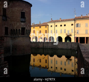 Werke-Burg und die umliegenden Gebäude spiegelt sich im Wasser während des Sonnenuntergangs. Italien. Stockfoto