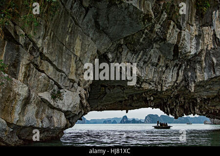 Touristen auf hölzerne Ruderboote und Kalkstein (Karst) Höhle, Vung Vieng Fischerdorf, Ha Long Bucht, Bai Tu Long Sektor, in der Nähe von Ha Long, Vietnam Stockfoto