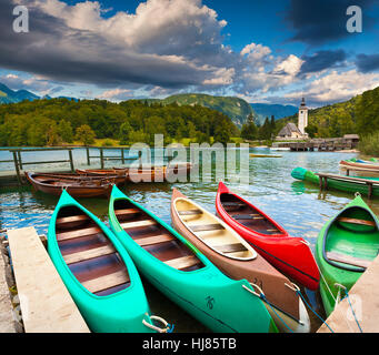 Bohinj See mit Booten und Kirche St. Johannes der Täufer, Nationalpark Triglav, Sloweniens. Stockfoto