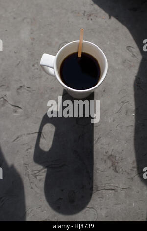Eine Kaffeetasse von oben, seine attraktive Schatten wirft. Stockfoto
