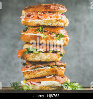 Nahaufnahme des Heaps Bagels mit Räucherlachs, Frischkäse, Eiern, Gemüse Stockfoto