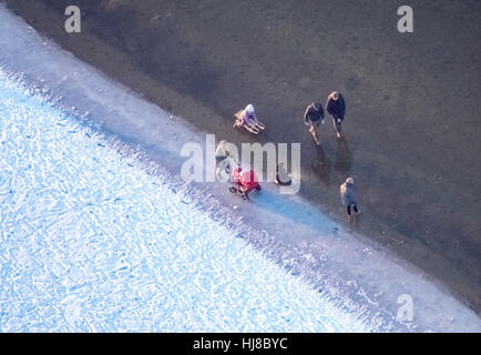 Sandbank mit Eis am Südufer, rücksichtslose ahnungslose Spaziergänger auf dem dünnen Eis, Winter-Wetter-Niedrigwasser am Möhnesee Stockfoto