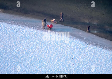 Sandbank mit Eis am Südufer, rücksichtslose ahnungslose Spaziergänger auf dem dünnen Eis, Winter-Wetter-Niedrigwasser am Möhnesee Stockfoto