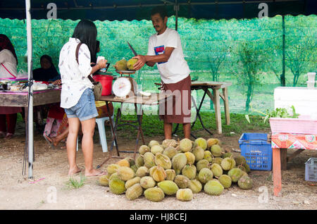 Reisenden asiatische Frau glücklich und Lächeln nach dem Kauf Durian Frucht von thai muslimischen Anbietern in lokale Straßenmarkt auf Koh Yao Noi am 6. Juni 2016 in P Stockfoto