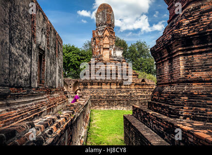 Frau mit Hut Blick auf antiken Ruinenstadt in Lopburi, Thailand Stockfoto