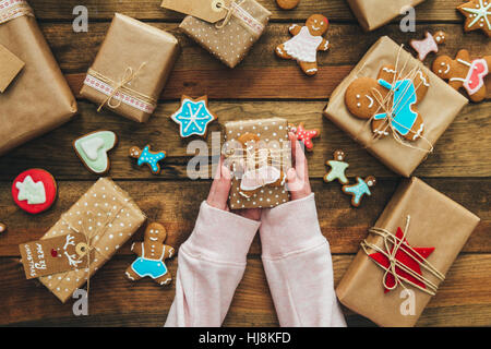 Mädchen hält Weihnachtsgeschenk mit Lebkuchenmann Stockfoto